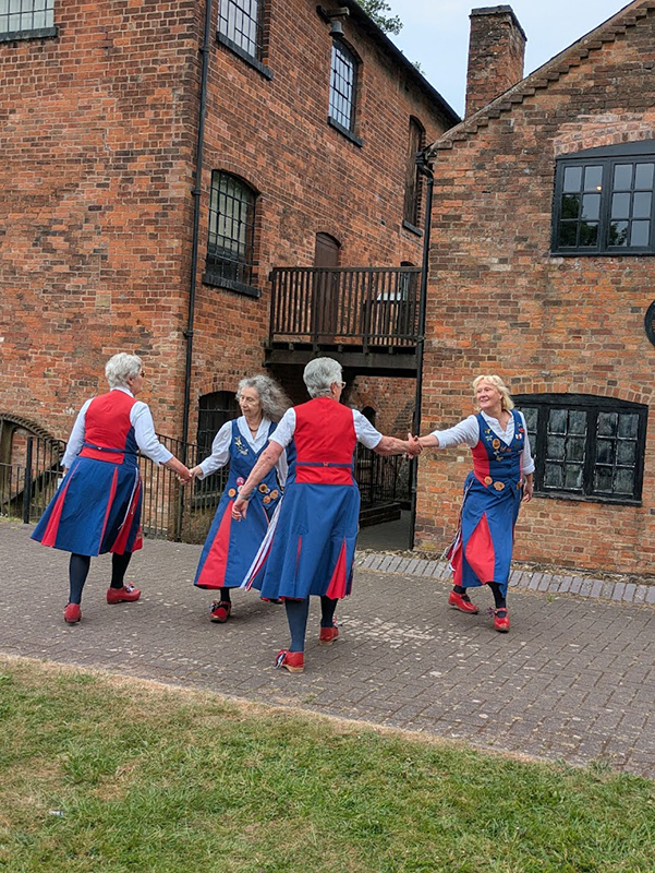 4 butterflies dancing in front of the Museum's static (at the moment) water wheel