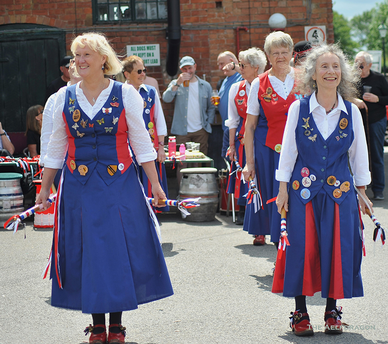 4 Butterfly dancers waiting to start, standing in front of beer barrels