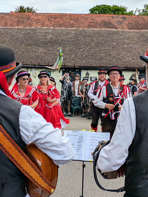 Old Meg dancers in their distinctive bowler hats approaching their musicians in the foreground
