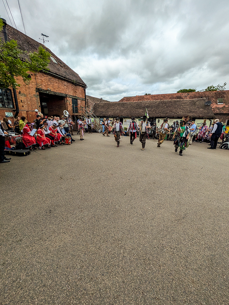 General view of Alvechurch Morris dancing in the 'arena' with other sides sitting and watching