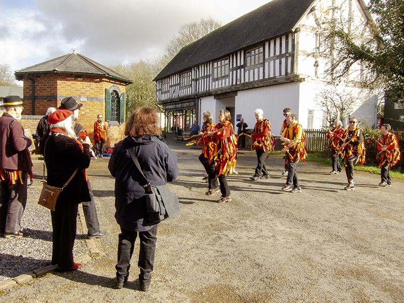 Blackadder morris dancers and band dancing in front of half timbered museum building