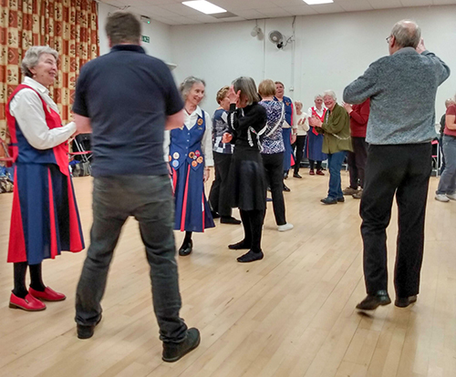 dancers from both teams standing and chatting in a break between moves