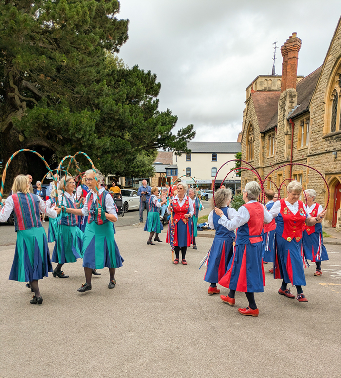 Butterfly dancers and Appleyard dancers in groups of 3 performing a joint dance with a Butterfly 'caller' in the centre