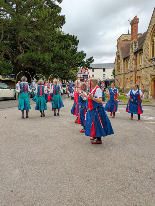 Butterfly and Appleyard dancers arranged like the spokes of a wheel, performing another joint dance.