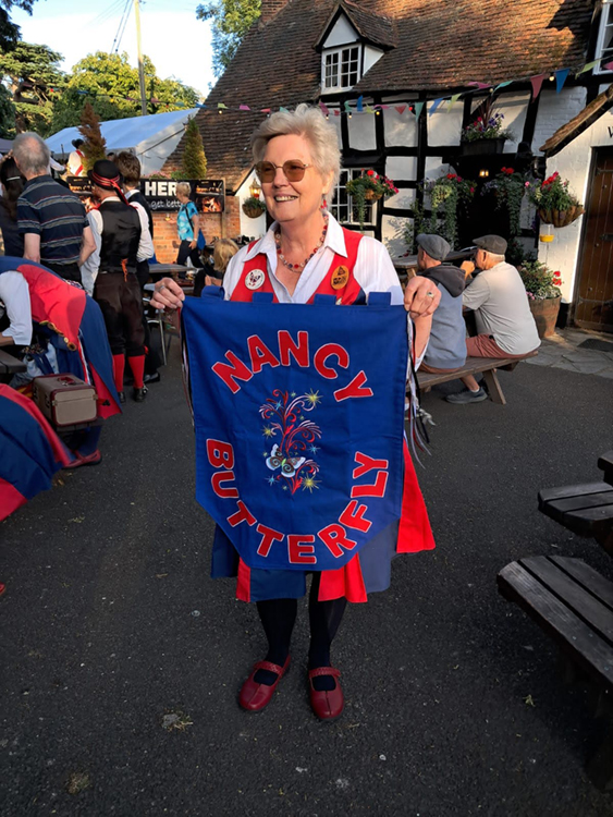 Butterfly dancer holding a newly made Pennant for Nancy Butterfly
