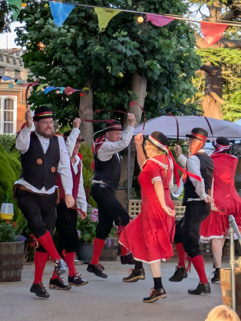 Old Meg Morris in their traditional red and black performing on the dance platform