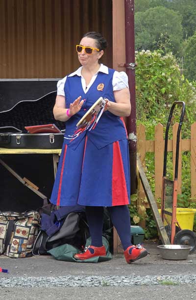 One of the Butterfly dancers, wearing sunglasses, accompanying on a tambourine