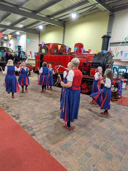 Dancing in the Engine shed at Highley in front of a bright red and black tank engine