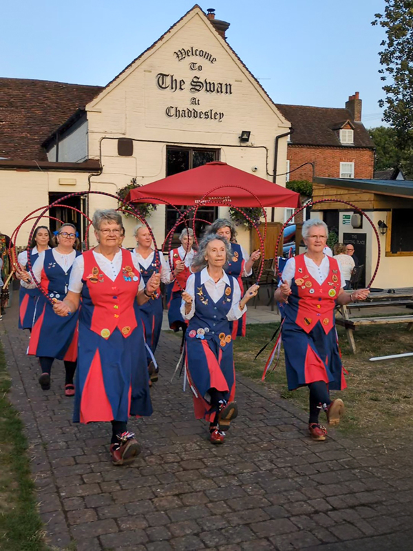 Nancy Butterfly in 3 rows of 3 seen from the front as they dance holding decorated hoops