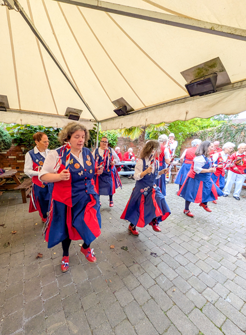 8 Nancy Butterfly dancers in 2 rows of 4, dancing under the canopy in the garden of the Dog and Partridge Inn, Alcester